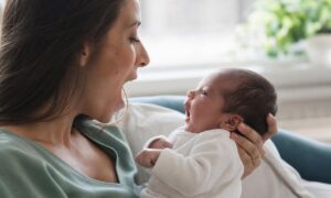 Neonato tra le braccia imita l’apertura della bocca del genitore.